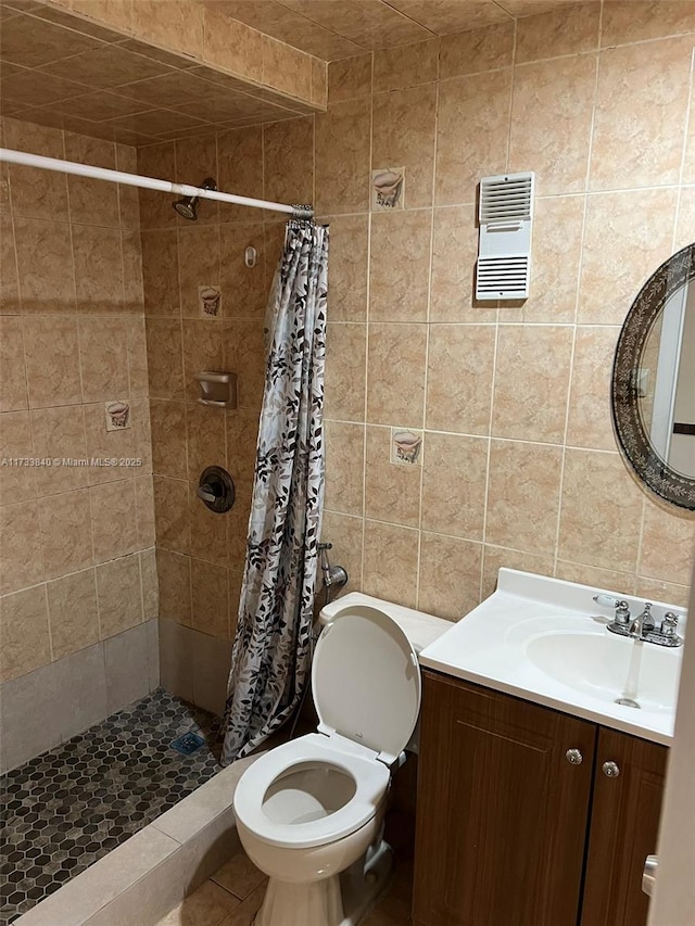 bathroom featuring tile walls, vanity, curtained shower, tile patterned floors, and toilet