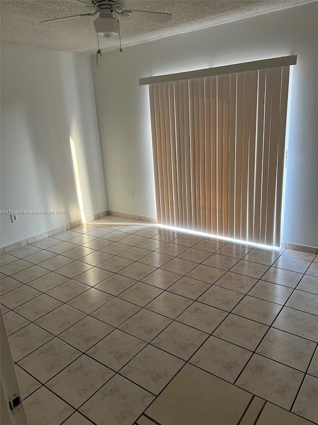 tiled spare room featuring ceiling fan, plenty of natural light, and a textured ceiling