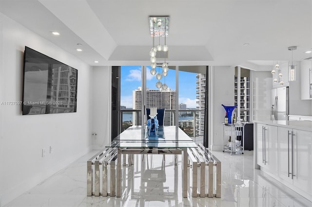 dining space featuring a raised ceiling and a chandelier