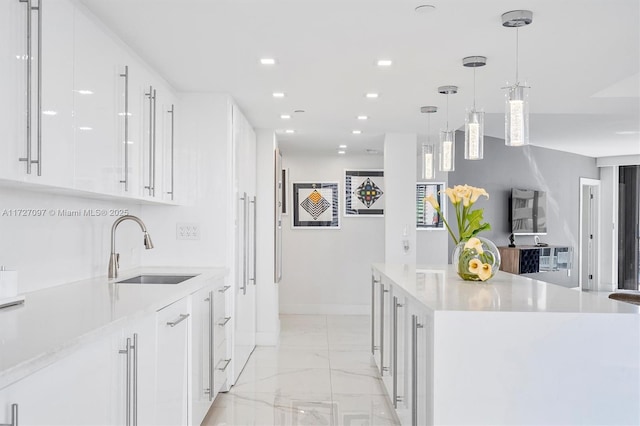 kitchen featuring pendant lighting, sink, and white cabinets