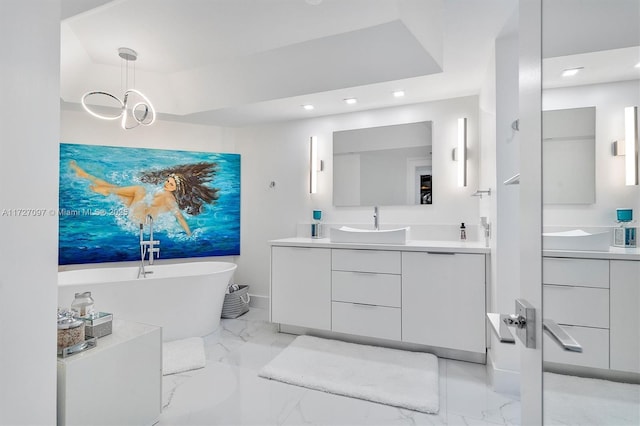 bathroom with vanity, a bath, and a tray ceiling