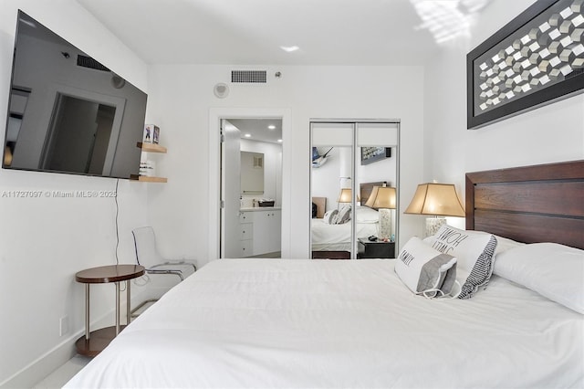 bedroom with ensuite bathroom and a closet