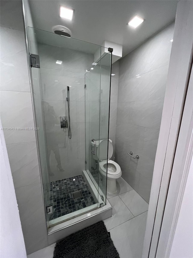 bathroom with an enclosed shower, tile patterned floors, and toilet