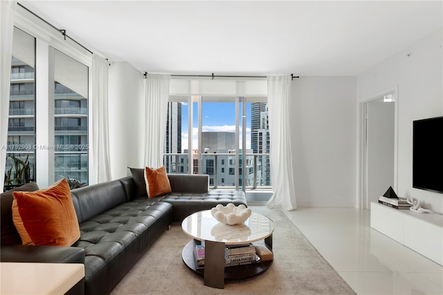 living room with light tile patterned floors and a wall of windows