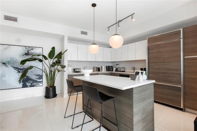 kitchen with white cabinetry, light tile patterned floors, and a center island