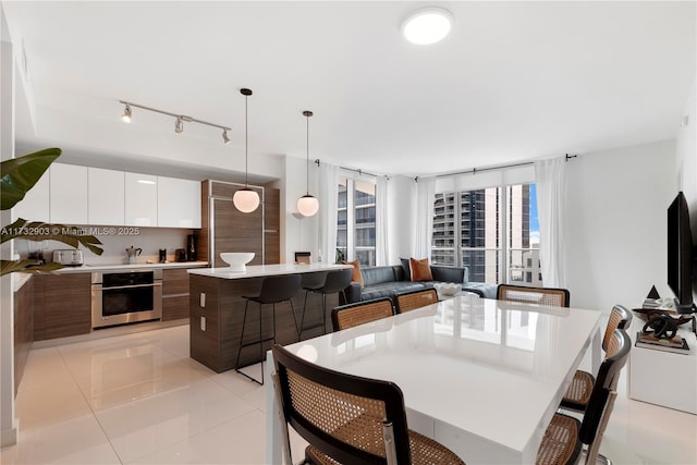 dining space featuring light tile patterned flooring and a wall of windows