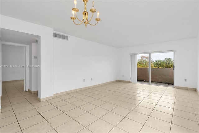 empty room with an inviting chandelier and light tile patterned floors