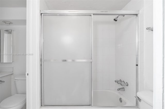 bathroom with enclosed tub / shower combo and toilet