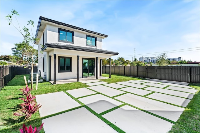 rear view of property featuring a patio area and a lawn