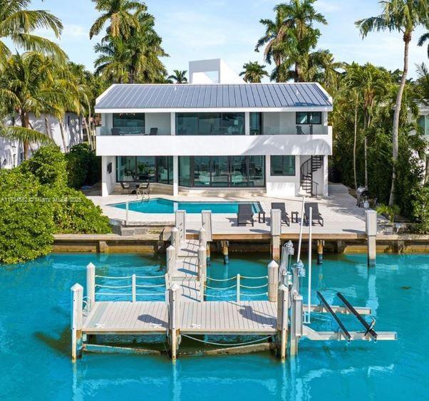 rear view of house with a patio and a water view