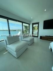 living area featuring concrete floors and a water view
