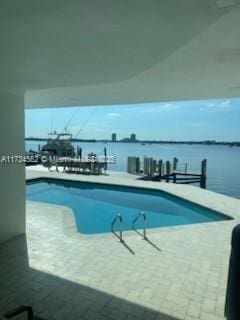 pool with a water view and a patio area