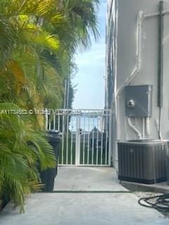 view of patio with central air condition unit and a balcony