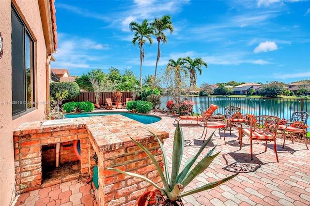 view of patio featuring a fenced in pool and a water view