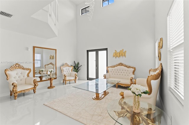 sitting room with a high ceiling and french doors