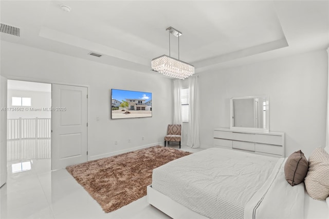 bedroom with light tile patterned floors and a tray ceiling