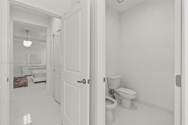 bathroom with tile patterned flooring, a bidet, and toilet