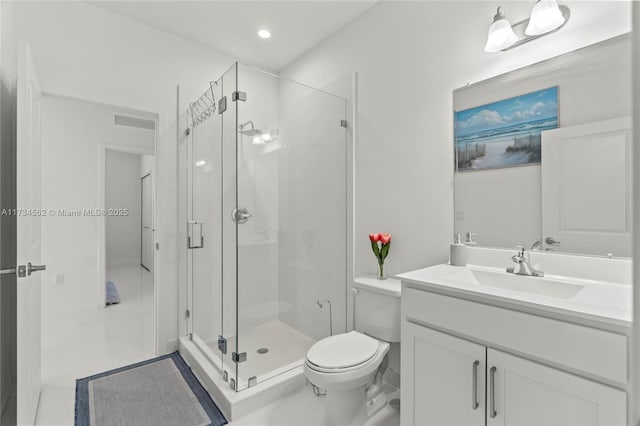 bathroom featuring vanity, toilet, and a shower with shower door