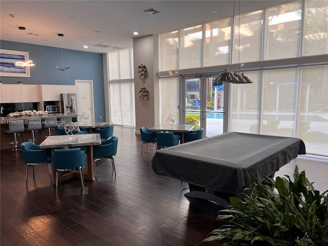 playroom with dark hardwood / wood-style flooring, billiards, expansive windows, and a high ceiling