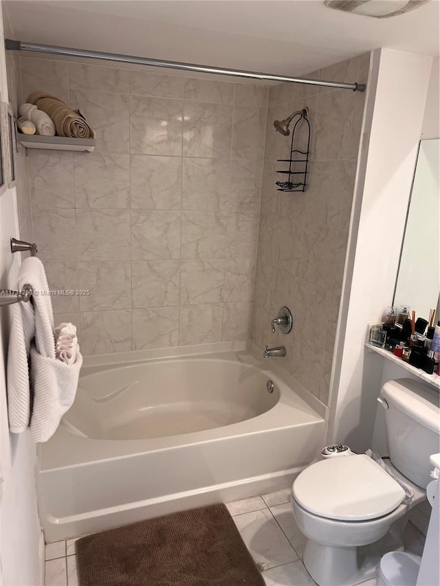 bathroom with tiled shower / bath combo, tile patterned floors, and toilet