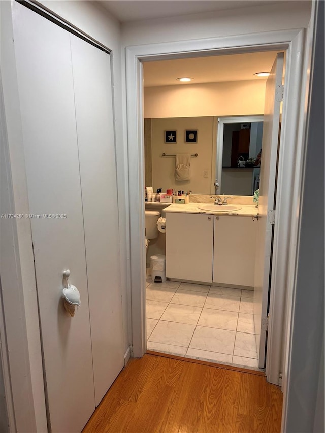 corridor with sink and light hardwood / wood-style flooring