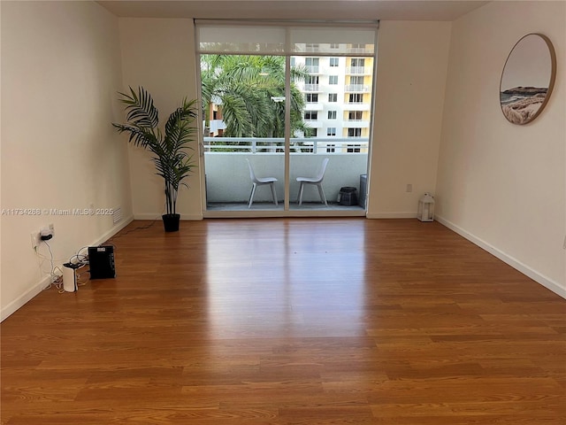 spare room featuring wood-type flooring and floor to ceiling windows