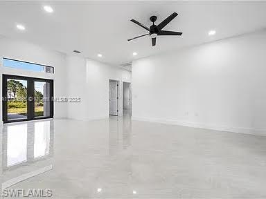 spare room with ceiling fan and french doors