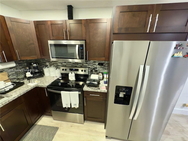 kitchen featuring tasteful backsplash, appliances with stainless steel finishes, and light stone countertops