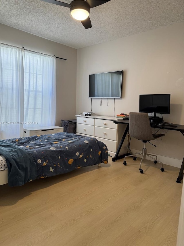 bedroom with ceiling fan, a textured ceiling, and light wood-type flooring