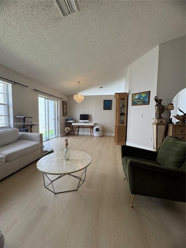 living room with a textured ceiling and light wood-type flooring