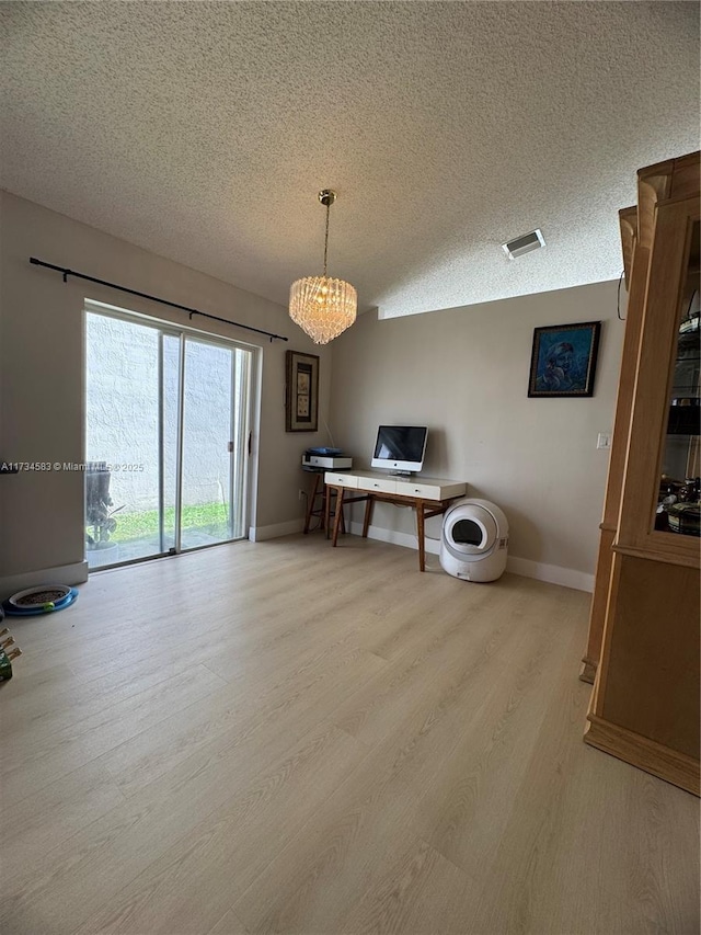 unfurnished office featuring light hardwood / wood-style flooring and a textured ceiling