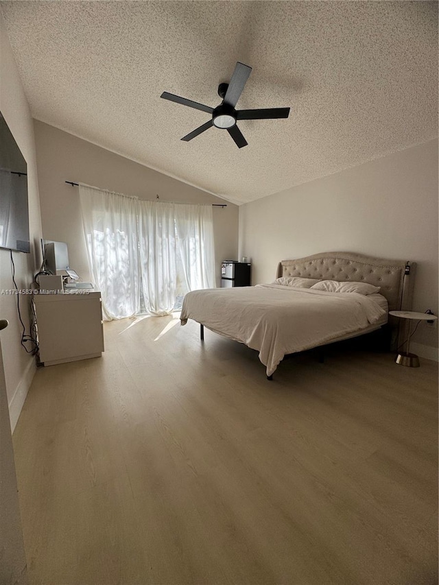 unfurnished bedroom with ceiling fan, lofted ceiling, wood-type flooring, and a textured ceiling