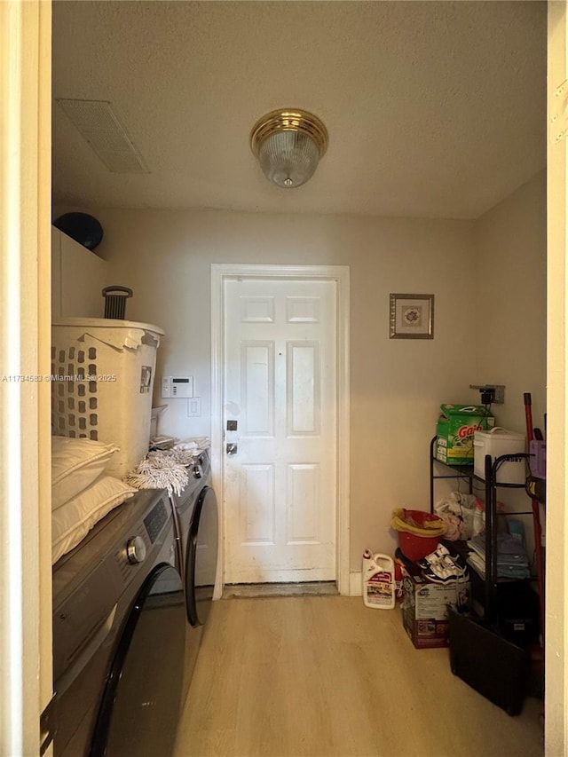 washroom with washer and dryer and light hardwood / wood-style flooring