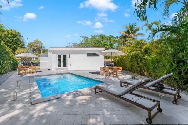 view of pool featuring a patio and central AC unit