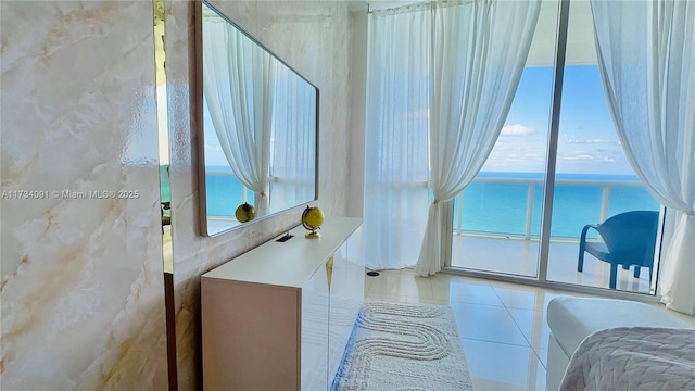 bathroom featuring a water view, tile patterned floors, and a healthy amount of sunlight