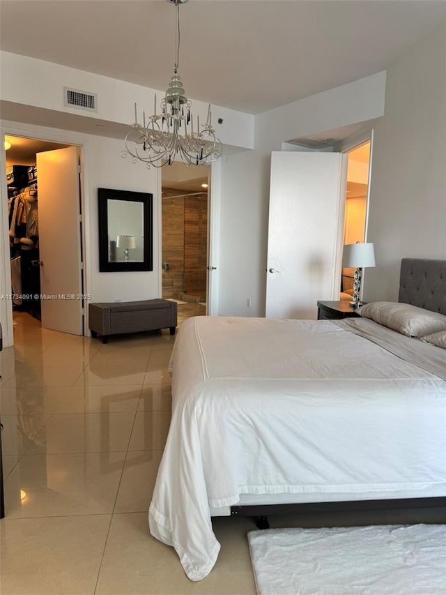 bedroom featuring tile patterned flooring, a walk in closet, and an inviting chandelier