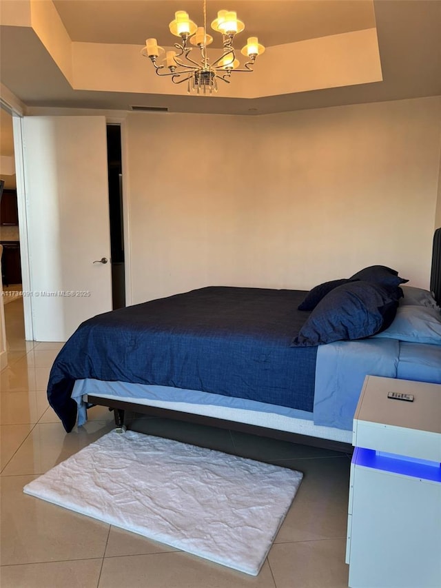 tiled bedroom with a chandelier and a raised ceiling