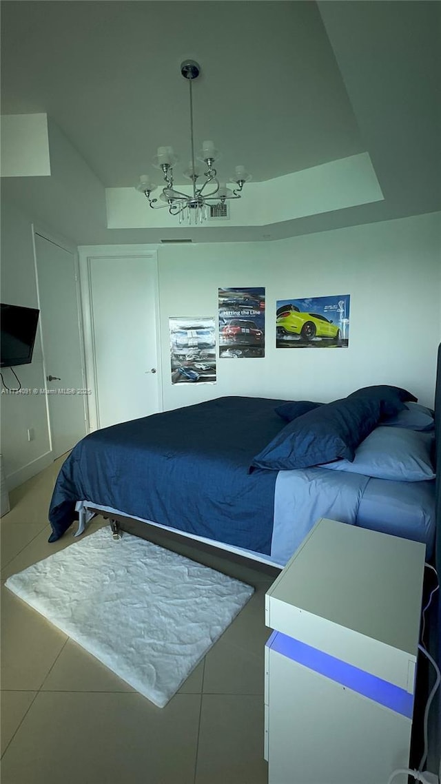 bedroom with tile patterned floors and an inviting chandelier