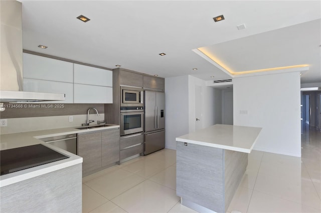 kitchen with sink, light tile patterned floors, white cabinetry, a center island, and built in appliances