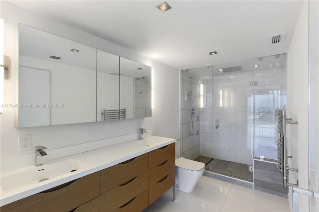 bathroom featuring tile patterned flooring, vanity, a shower with shower door, and toilet