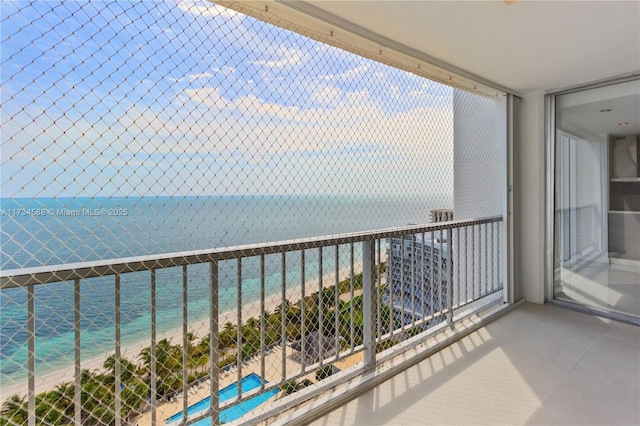 balcony featuring a water view and a view of the beach