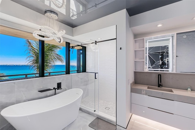 bathroom featuring independent shower and bath, vanity, a water view, and a notable chandelier