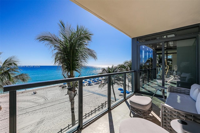 balcony featuring a water view and a view of the beach