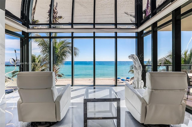 sunroom with a water view and a view of the beach