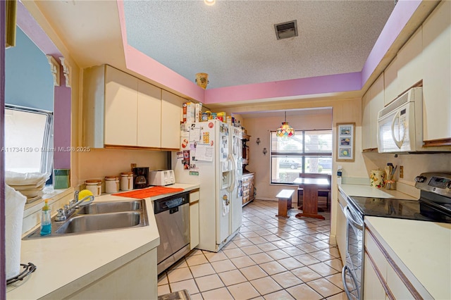 kitchen featuring pendant lighting, sink, light tile patterned floors, stainless steel appliances, and a textured ceiling