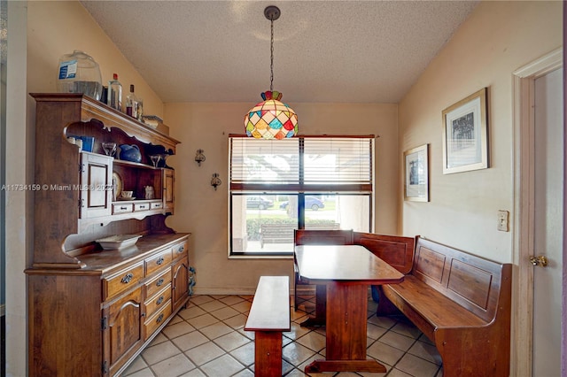 dining area with light tile patterned floors and a textured ceiling