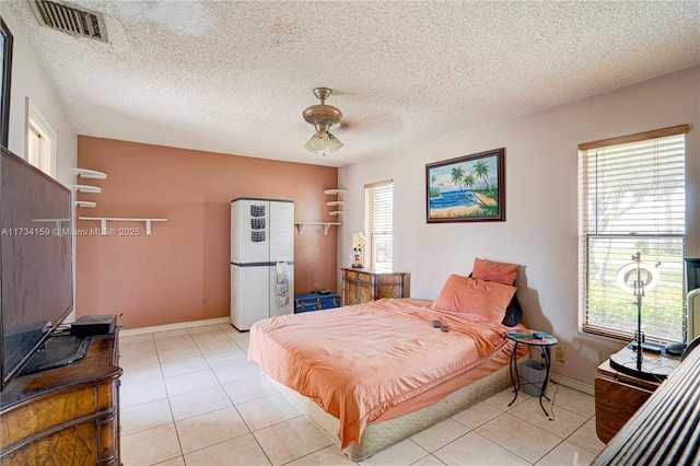 bedroom with multiple windows, light tile patterned floors, and ceiling fan