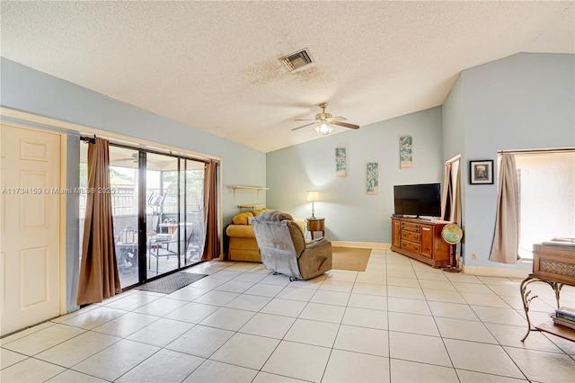 living room with light tile patterned floors, vaulted ceiling, a textured ceiling, and ceiling fan