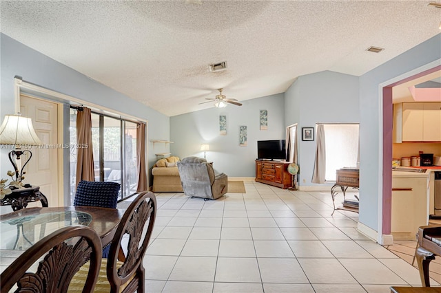 living room with lofted ceiling, light tile patterned floors, a textured ceiling, and ceiling fan