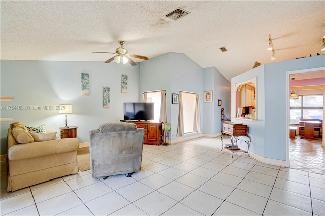 living room featuring light tile patterned flooring, ceiling fan, lofted ceiling, and a textured ceiling